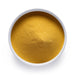 Dolce Superfoods organic mango powder in white bowl on white background