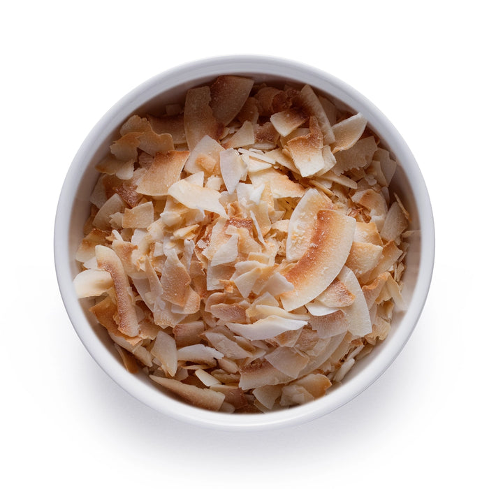Dolce Superfoods organic toasted coconut chips in white bowl on white background