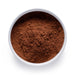 Dolce Superfoods organic cacao powder in white bowl on white background