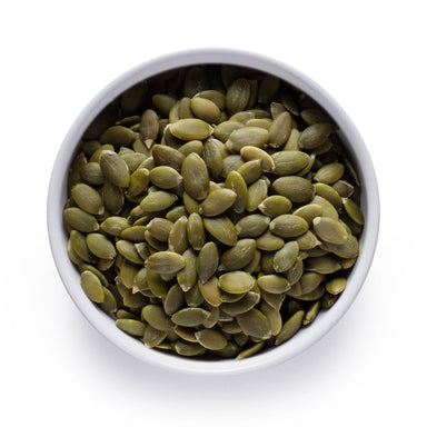Dolce Superfoods organic pumpkin seeds in white bowl on white background