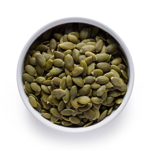 Dolce Superfoods organic pumpkin seeds in white bowl on white background