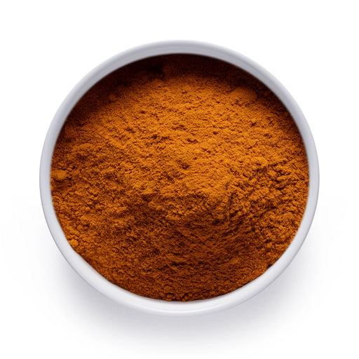 Dolce Superfoods organic turmeric powder in white bowl on white background