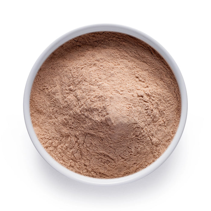 Dolce Superfoods organic lucuma powder in white bowl on white background