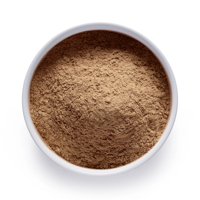 Dolce Superfoods organic maca root powder in white bowl on white background