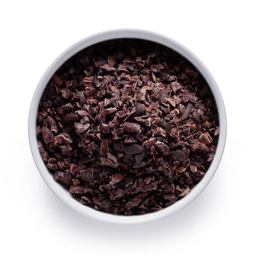 Dolce Superfoods organic cacao nibs in white bowl on white background