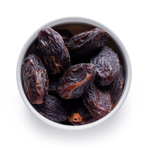 Dolce Superfoods organic Medjool dates in white bowl on white background