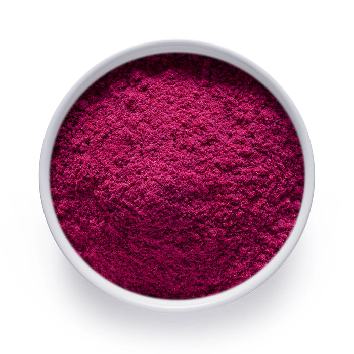 Bulk dragon fruit powder in a white bowl, vivid magenta freeze dried pitaya for wholesale superfood blends