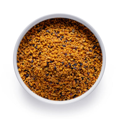 Bulk organic bee pollen in a white bowl, golden multicolor granules sold wholesale by Dolce Superfoods