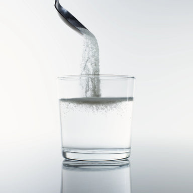 Collagen powder dissolving into glass of water – Dolce Superfoods bulk organic wholesale ingredient
