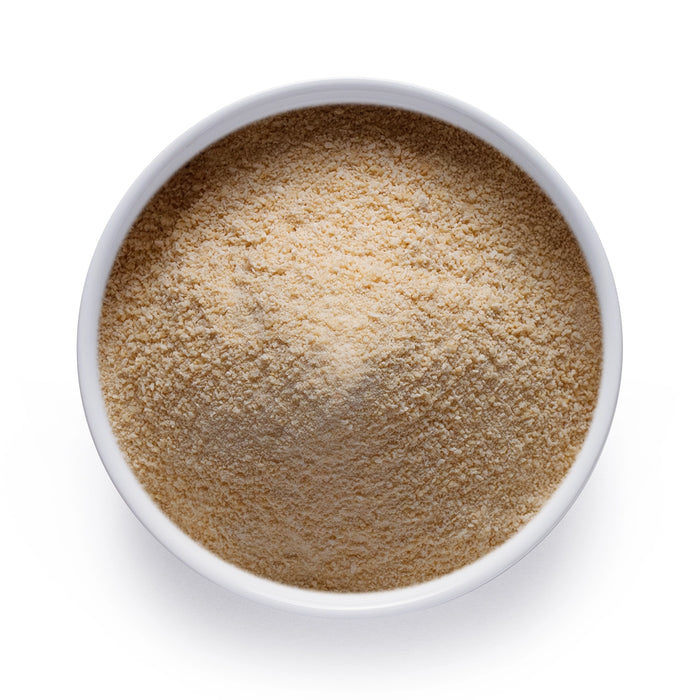 Bulk organic vanilla powder in a white bowl, finely ground vanilla for wholesale baking, beverages, and functional food use.