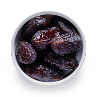 Bulk organic Medjool dates in a white bowl, whole pitted dates for wholesale sweetening, baking, and food manufacturing.