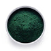 Bulk organic spirulina powder in a white bowl, deep green superfood powder for wholesale smoothies, beverages, and nutrition blends.