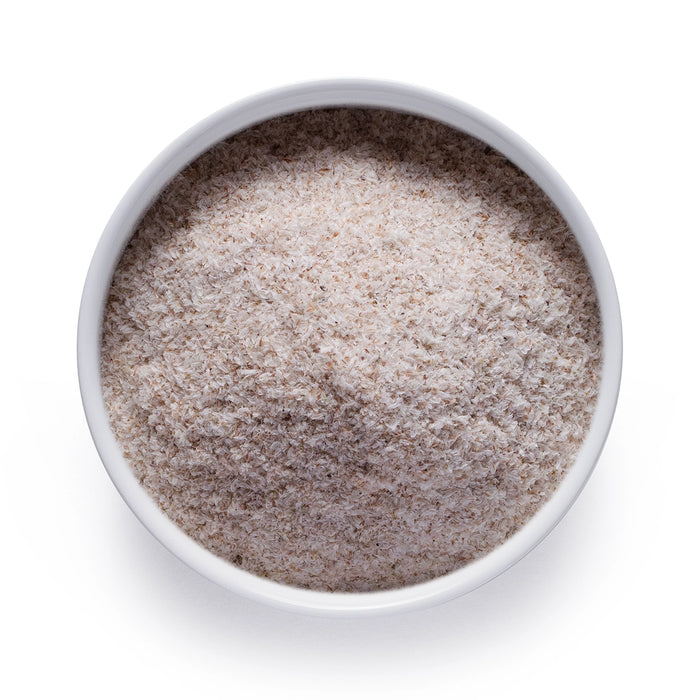 Bulk whole psyllium husk powder in a white bowl, natural fiber ingredient for wholesale baking, supplements, and digestive recipes.