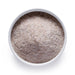 Bulk whole psyllium husk powder in a white bowl, natural fiber ingredient for wholesale baking, supplements, and digestive recipes.