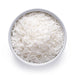 White bowl filled with shredded organic coconut flakes on a white background, top-down view