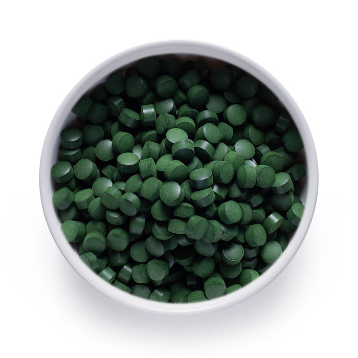 Bulk organic chlorella tablets in a white ceramic bowl, wholesale superfood ingredient by Dolce Superfoods