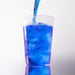 Dolce Superfoods blue spirulina drink poured over ice in clear cup