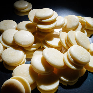 Dolce Superfoods cacao butter wafers on dark background
