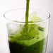 Dolce Superfoods ceremonial matcha poured over ice in clear glass