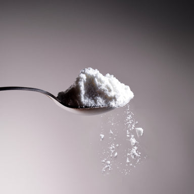 Dolce Superfoods organic coconut milk powder on metal spoon