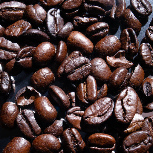 Dolce Superfoods organic whole bean coffee beans close up on dark surface