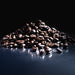 Dolce Superfoods organic whole bean coffee beans piled on reflective surface against dark background